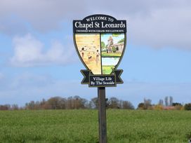 A welcome sign for Chapel St Leonards in a field by the seaside