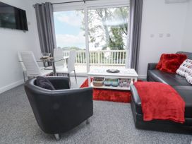 A living room with a sofa and dining area at I C Lundy Too Bideford Bay Holiday Park near Woolfardisworthy