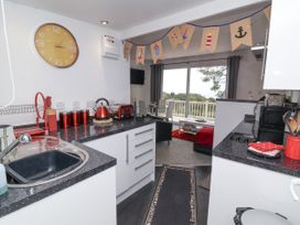 A kitchen with appliances and a living area at I C Lundy Too Bideford Bay Holiday Park near Woolfardisworthy