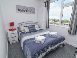 A bedroom with a bed and window at I C Lundy Too Bideford Bay Holiday Park near Woolfardisworthy