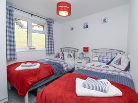 A bedroom with two beds and a window at I C Lundy Too Bideford Bay Holiday Park near Woolfardisworthy