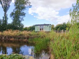 A shepherd hut beside a body of water at Shepherds hut in 