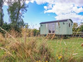 A shepherd's hut surrounded by grass and trees at Shepherds hut