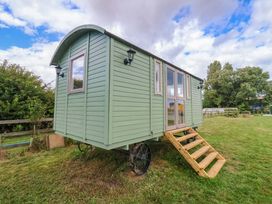 A shepherd's hut with steps and windows outdoors at Shepherds hut