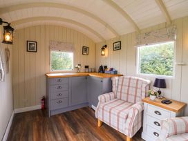 A kitchen area with a sink and seating at Shepherds hut