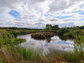 A landscape with a pond and greenery at Shepherds hut