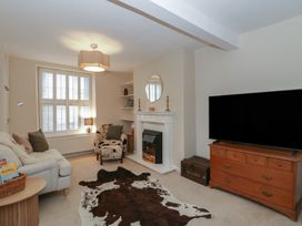 A living room with a fireplace and television at Cariad Cottage in Hereford