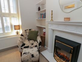 A living room with an armchair and fireplace at Cariad Cottage in Hereford