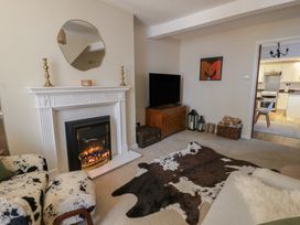 A living room with a fireplace and television at Cariad Cottage Hereford