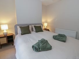 A bedroom with a bed and lamps at Cariad Cottage in Hereford