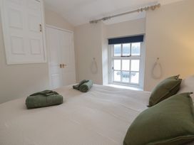 A bedroom with a bed and towels at Cariad Cottage Hereford