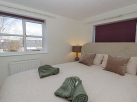 A bedroom with a bed and lamp at Cariad Cottage Hereford