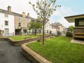 A garden area with a tree and grass at Cariad Cottage in Hereford
