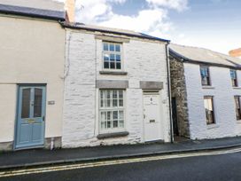 A house with a white facade and a blue door at Cariad Cottage in Hay-On-Wye