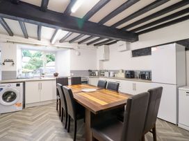 A kitchen with a dining table and appliances at Plas Yn Bonwm Corwen