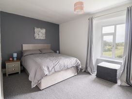 A bedroom with a bed and nightstand at Plas Yn Bonwm in Corwen
