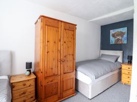 A bedroom with a wardrobe and bed at Plas Yn Bonwm in Corwen