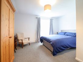 A bedroom with a bed and wardrobe at Plas Yn Bonwm in Corwen