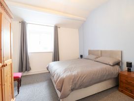 A bedroom with a bed and wardrobe at Plas Yn Bonwm in Corwen