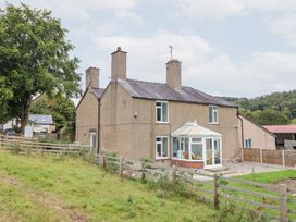 A house with a conservatory and fence at Plas Yn Bonwm in Corwen