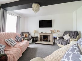 A living room with a fireplace and television at Plas Yn Bonwm in Corwen