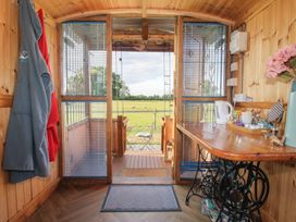An interior view with a table and chair at Sharon's Shepherd Hut Oswestry
