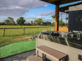 A garden with a hot tub and outdoor seating at Sharon's Shepherd Hut in Oswestry