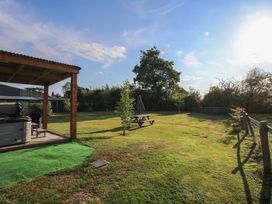 A garden with a gazebo and hot tub at Sharon's Shepherd Hut in Oswestry
