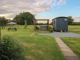 An outdoor area with a shepherd hut and hot tub at Sharon's Shepherd Hut Oswestry
