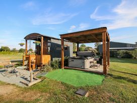 A shepherd hut and hot tub in an outdoor area at Sharon's Shepherd Hut in Oswestry