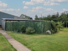 A hut surrounded by a green fence in Sharon's Shepherd Hut Oswestry