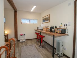A kitchen area with a table and bar stools at Sharon's Shepherd Hut in Oswestry