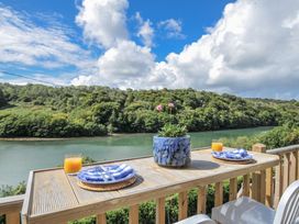 An outdoor dining area with a table and view at Mayhurst in Looe