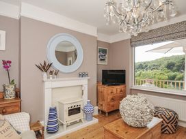 A living room with a fireplace and a television at Mayhurst in Looe