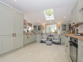 A kitchen with cabinets and seating area at Mayhurst in Looe
