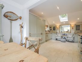 A kitchen with a dining table and cushioned seating at Mayhurst in Looe