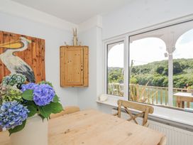 A dining room with a view of a river at Mayhurst in Looe