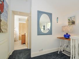 A hallway with a mirror and lamp at Mayhurst Looe