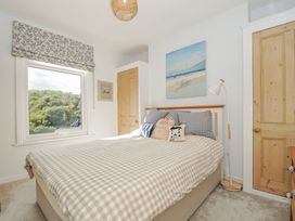 A bedroom with a bed and window at Mayhurst in Looe