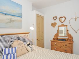 A bedroom with a bed and dresser at Mayhurst in Looe