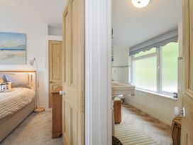 A bedroom and bathroom with a bed and bathtub at Mayhurst in Looe