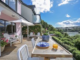 An outdoor dining area with a table and chairs at Mayhurst in Looe