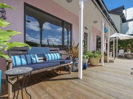 An outdoor seating area with a bench and potted plants at Mayhurst in Looe