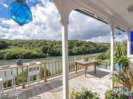 An outdoor area with table and chairs overlooking a river at Mayhurst in Looe