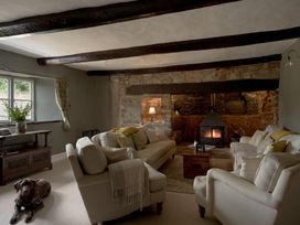 A living room with sofas and a fireplace at Holwell Farmhouse in Bampton