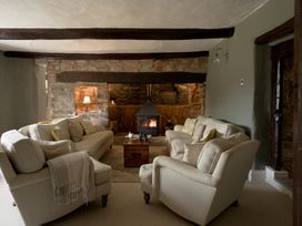 A living room with a fireplace and sofas at Holwell Farmhouse in Bampton