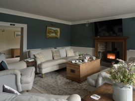 A living room with a sofa and fireplace at Holwell Farmhouse in Bampton