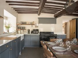 A kitchen with a dining table and oven at Holwell Farmhouse in Bampton