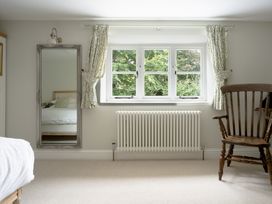 A bedroom with a bed and a window at Holwell Farmhouse in Bampton