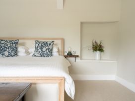 A bedroom with a bed and decorative pillows at Holwell Farmhouse in Bampton